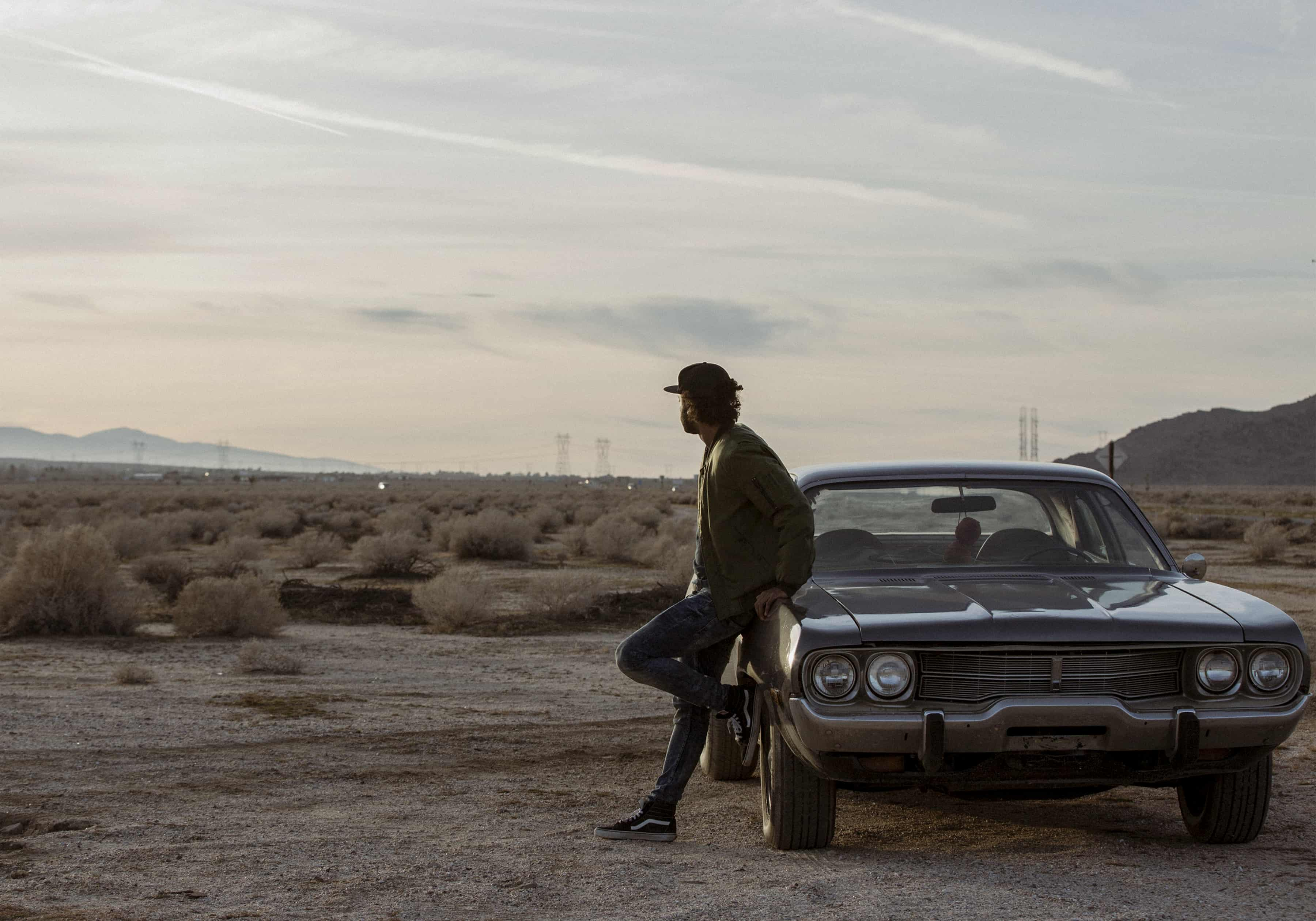 Photo of a guy deep in thought, staring out into the desert.